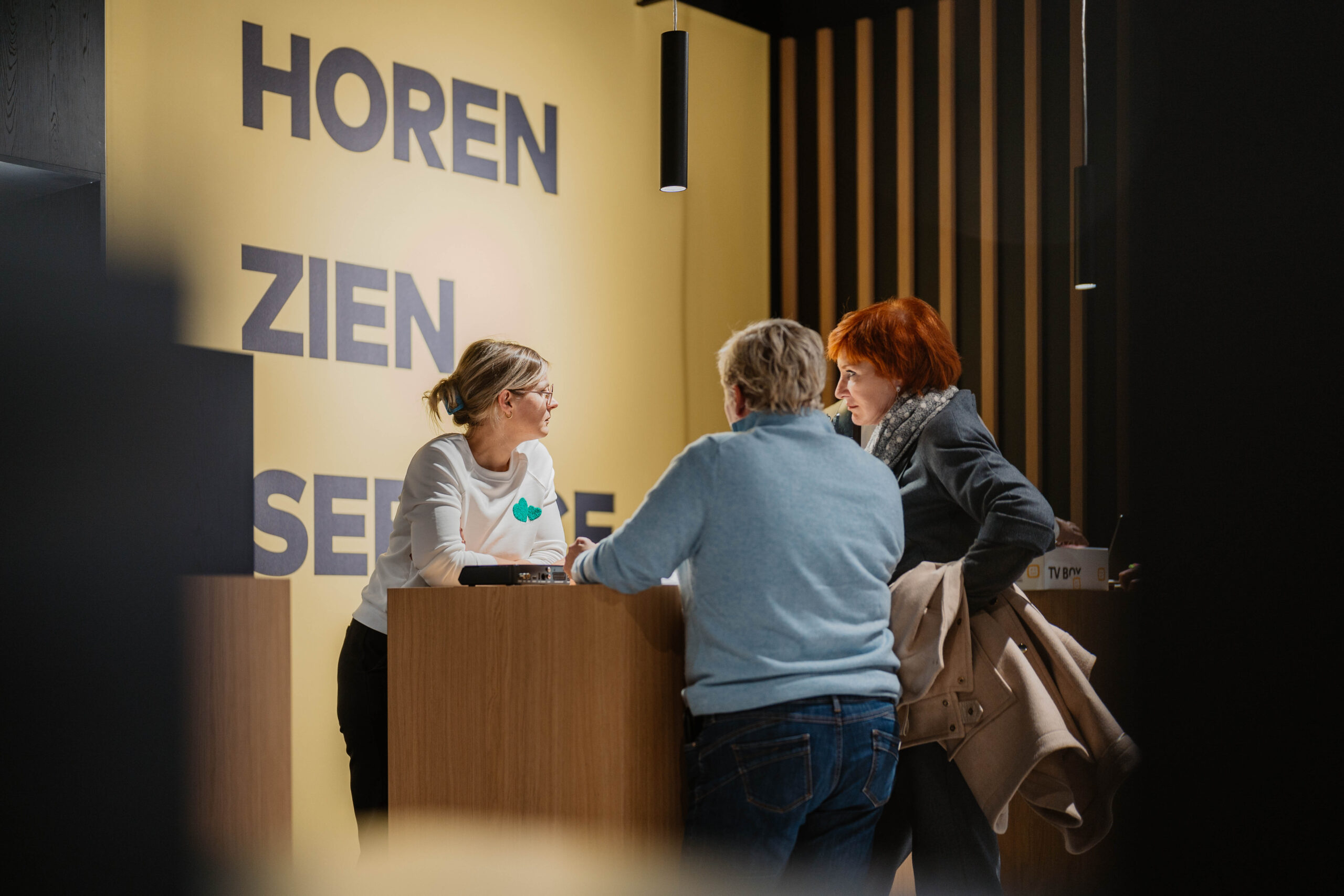 Telenet-verkoper helpt twee klanten aan de Telenet-balie in de Spectrum-winkel in Kortrijk - Telenet-abonnementen, persoonlijk advies, Spectrum service